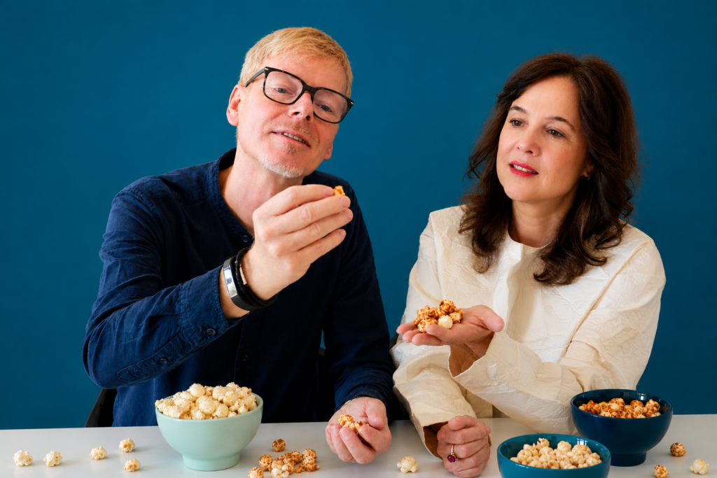 Angelika Ballosch und Kai Bösterling diskutieren angeregt. Vor ihnen liegt Popcorn auf dem Tisch.